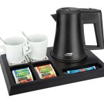 Black hospitality tray with black kettle 2 white mugs, spoons inside the mug. The tray shows single use fruit tea and sugar sachets. Items not included unless specified - tray only